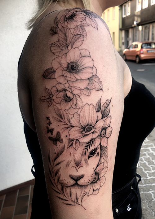 Loewe und Blumen Tattoo